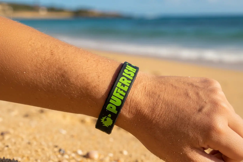 Pulso usando bracelete Pufferfish preto e verde na praia